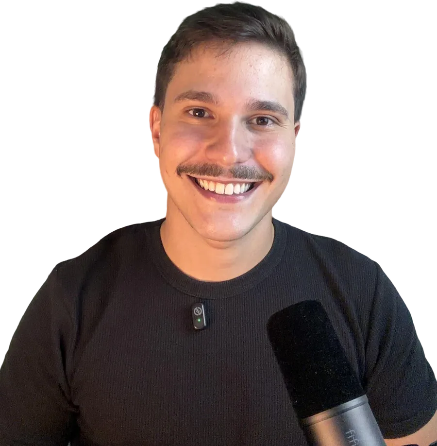 Teacher Lucas sorrindo, de camiseta preta, com um microfone à frente